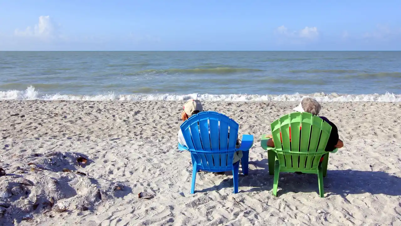Close up on a plate of mashed potatoes, topped with baked pork chops with cream of mushroom soup, and a side of green beans.