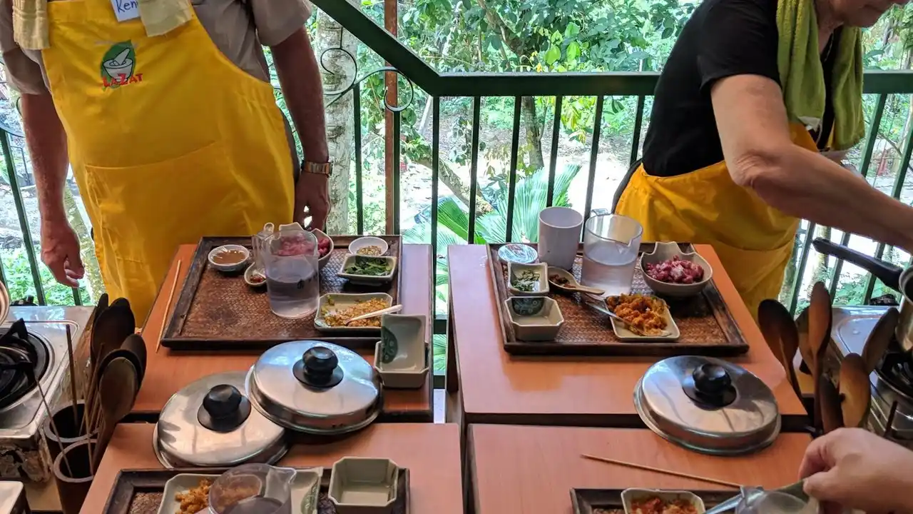 blue bowl of black bean beef tortilla soup on a board with cilantro and shredded cheese in background