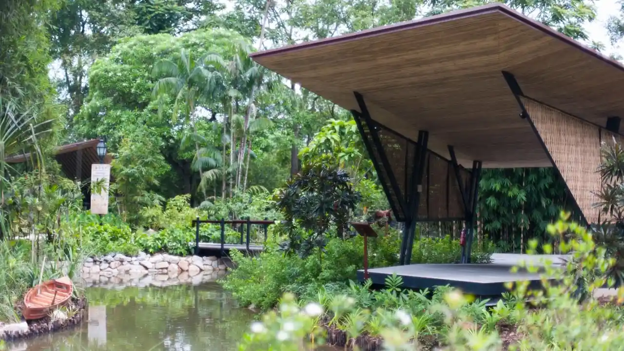 blue bowl of black bean beef tortilla soup on a board with cilantro and shredded cheese in background
